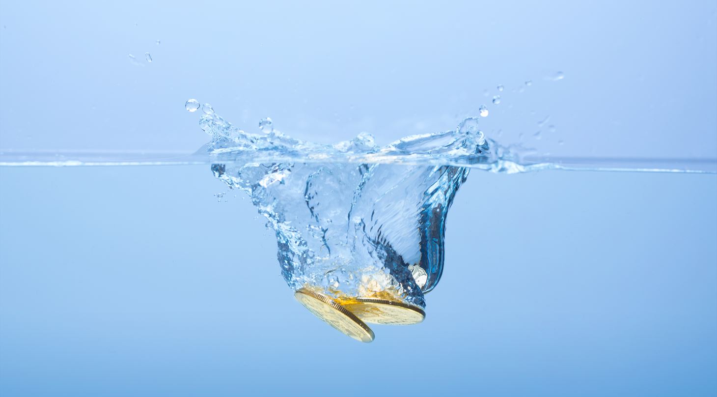 Guldmønter der ligger i blåt vand